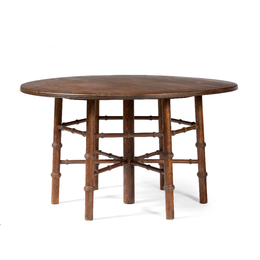 In the manner of Philip Webb Oak round table sloping turned legs and supports around a central