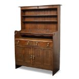 Arts & Crafts Oak dresser finished with carved rose motifs, brass handles, stylised cut-outs 55cm