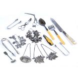 Collection of silver including sugar tongs, spoons, white metal umbilical cord scissors, spirit