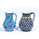 Two Iznik style jugs Turkey, 20th Century the first in ground blue, decorated with repeating