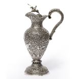 Silver Kutch claret jug India,late 19th Century of baluster form, embossed with floral, foliate
