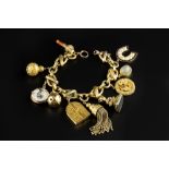 A CHARM BRACELET, the fancy hoop-linked bracelet with later clasp, suspending a collection of