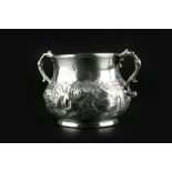 A CHARLES II SILVER PORRINGER, the bulbous body embossed and chased with foliage, having twin scroll