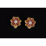 A PAIR OF RUBY AND DIAMOND EAR CLIPS, circa 1940, each stylised flowerhead panel centred with an old