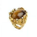 A TIGER'S EYE AND DIAMOND DRESS RING BY GEORGE WEIL, circa 1970-75, the oval cabochon tiger's eye