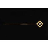 A DIAMOND AND HALF PEARL SET STICK PIN, the openwork lozenge-shaped panel centred with an old-cut