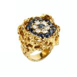 A SAPPHIRE AND DIAMOND CLUSTER RING, of pierced and textured abstract design, centred with a