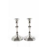A PAIR OF SILVER CANDLESTICKS, with knopped and tapered square section stems, on faceted octagonal