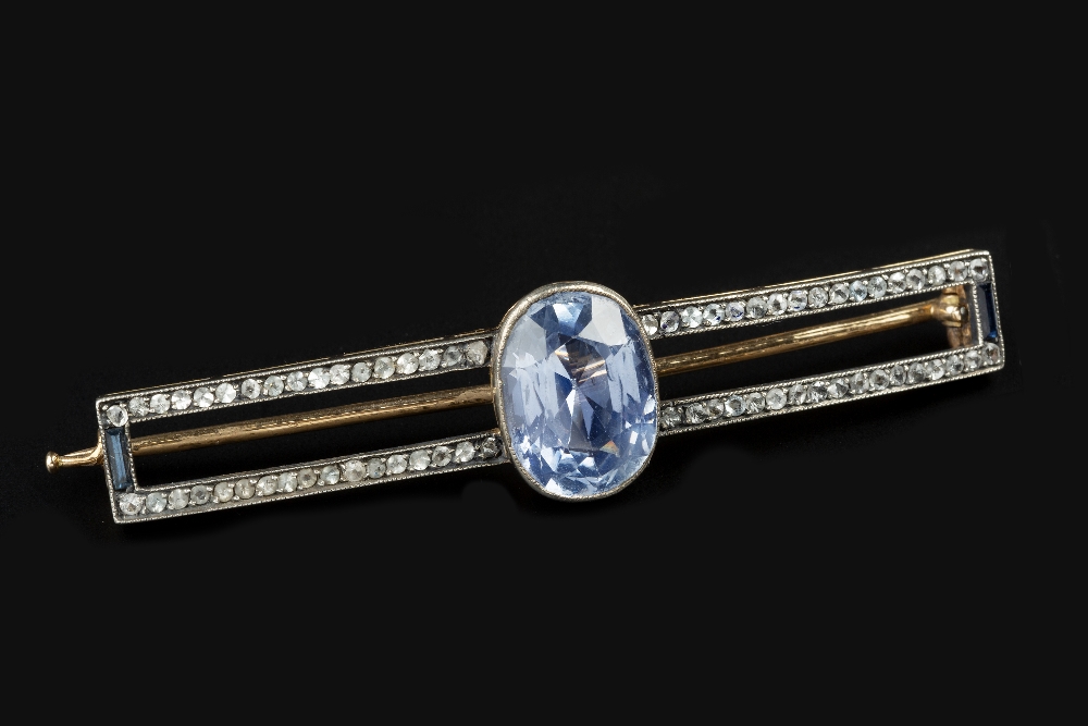 A SAPPHIRE SET PANEL BROOCH, the shaped openwork rectangular panel edged with a blue and white stone