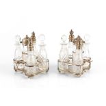 A PAIR OF SILVER FIVE SECTION CRUET STANDS, each fitted with cut glass bottles and jars, with beaded