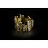 A DIAMOND SET BAND RING, designed as an abstract arrangement of engraved baton-shaped panels and