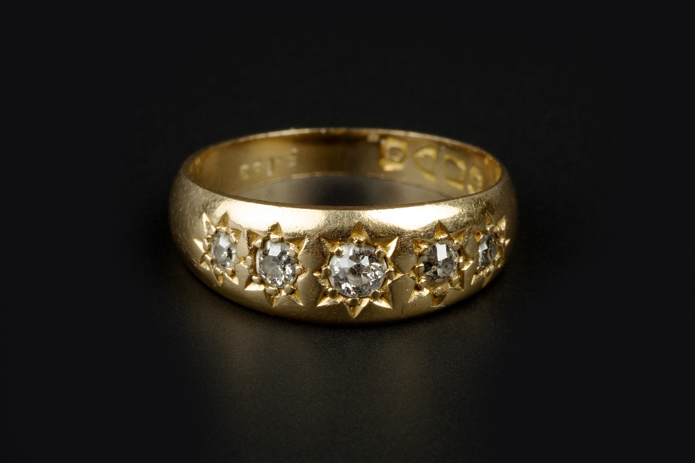 A DIAMOND FIVE STONE RING, the graduated old-cut diamonds in gypsy star settings, 18ct gold mounted,