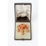 A 19TH CENTURY CORAL PANEL BROOCH, modelled as a carved coral corallium rubrum cherub amongst