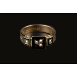 A LATE VICTORIAN MEMORIAL RING, centred with three half pearl and black enamel panels, to an