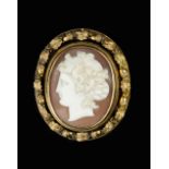 A VICTORIAN OVAL SHELL CAMEO BROOCH, carved to depict a classical female portrait in profile, with