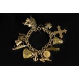 A CHARM BRACELET, the double-curb link bracelet suspending a collection of yellow metal, white metal