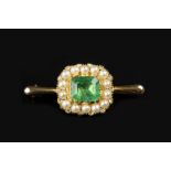 AN EMERALD, HALF PEARL AND DIAMOND CLUSTER BROOCH, the rectangular step-cut emerald with canted