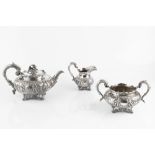 A WILLIAM IV SILVER THREE PIECE TEA SERVICE, chased and embossed with figures in garden