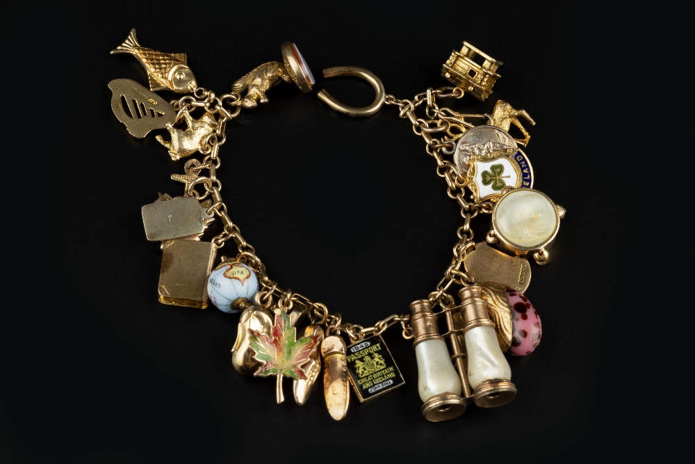 A CHARM BRACELET, the fancy-link bracelet stamped '9c', suspending a collection of assorted 9ct