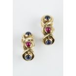 A PAIR OF RUBY AND SAPPHIRE SET EAR CLIPS, of half hoop twist design, each with a trio of cabochon