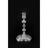 A GEORGE II SILVER TAPER STICK, with knopped stem, and shaped scallop and scroll cast base, by