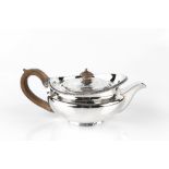 A GEORGE III SILVER TEAPOT, of compressed form, with gadrooned border and fruitwood handle and knop,