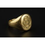 A YELLOW PRECIOUS METAL SIGNET RING, the oval panel with engraved monogram, ring size N