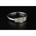 A DIAMOND THREE STONE RING, the graduated round brilliant-cut diamonds in stepped square settings,