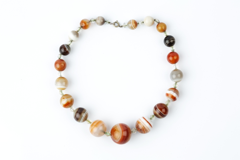 A BANDED AGATE BEAD NECKLACE, the graduated agate beads with faceted spacers between, together