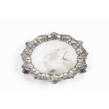 AN EDWARDIAN SILVER SMALL SALVER, with shaped scallop and scroll cast border on scroll feet, by John