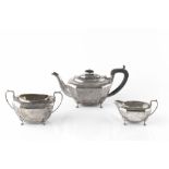 A SILVER THREE PIECE TEA SERVICE, of faceted design on cabriole legs, the teapot with ebonised