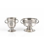 AN EDWARDIAN SILVER TWIN HANDLED PEDESTAL BOWL, and matching twin handled goblet, relief decorated