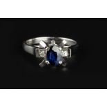 A SAPPHIRE AND DIAMOND DRESS RING, the oval mixed-cut sapphire in abstract claw setting, between two