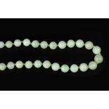 A JADEITE BEAD NECKLACE, the single strand of graduated jadeite beads to a barrel-shaped clasp