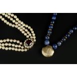 A CULTURED PEARL TRIPLE STRAND NECKLACE, the graduated cultured pearls with an oval mixed-cut garnet