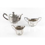 AN EDWARDIAN SILVER THREE PIECE BACHELOR'S TEA SERVICE, with part lobed decoration, the teapot