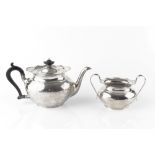 A SILVER TEAPOT, of shaped oval form, with ebonised handle and knop, and matching twin handled