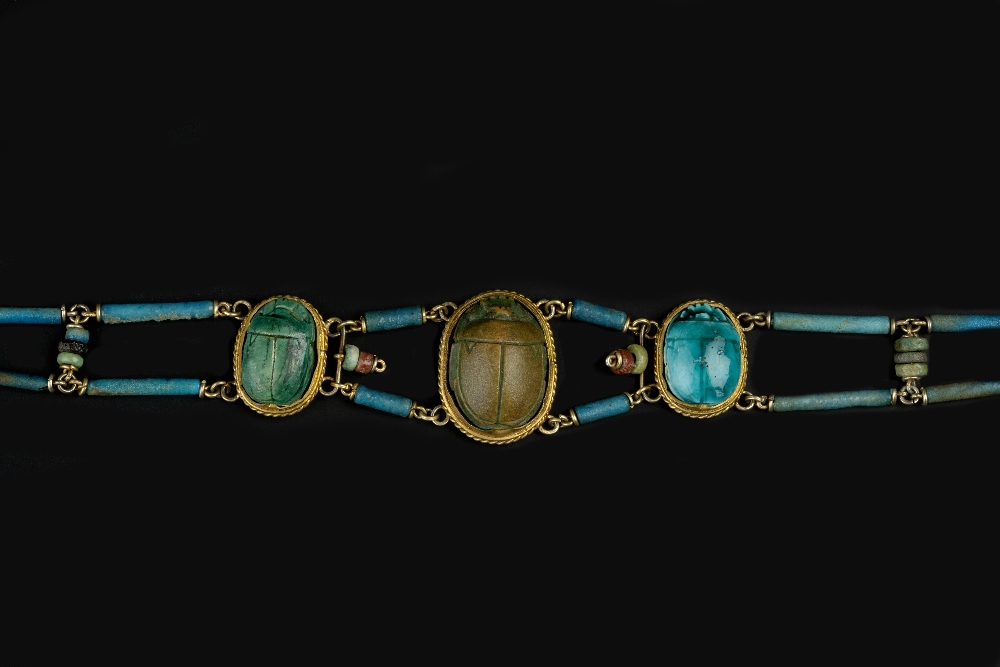 A SCARAB BRACELET, the baton and bead-link bracelet spaced by three graduated scarabs, length 18.