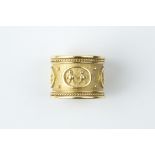 AN 18CT GOLD DRESS RING BY ELIZABETH GAGE, the wide textured band applied with figures, beads and