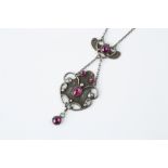 AN ARTS AND CRAFTS PENDANT NECKLACE, the cartouche-shaped panel with scrolled wirework and bead
