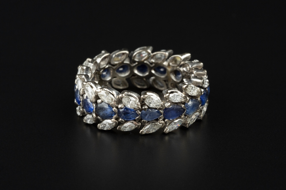 A SAPPHIRE AND DIAMOND FULL HOOP ETERNITY RING, centred with a line of pear-shaped mixed-cut