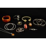 A COLLECTION OF JEWELLERY, comprising a graduated amber panel bracelet, a gilt torque bangle with