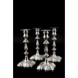 A SET OF FOUR EDWARDIAN SILVER CANDLESTICKS, with knopped stems and shaped square bases, by