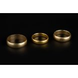 THREE WEDDING BANDS, comprising a 22ct gold wedding band, and two 9ct gold examples (3)
