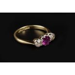 A RUBY AND DIAMOND THREE STONE RING, the circular mixed-cut ruby claw set between two old-cut