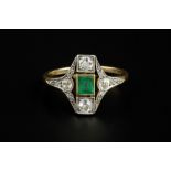 AN EMERALD AND DIAMOND PANEL RING, circa 1915-25, the lozenge-shaped panel centred with a