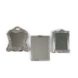 AN EDWARDIAN SILVER MOUNTED EASEL DRESSING TABLE MIRROR, of shaped outline, repoussé decorated