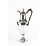 A GEORGE III SILVER HOT WATER JUG, of pedestal urn form, with beaded borders and fruitwood handle by