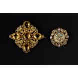 AN EARLY 19TH CENTURY VARI GEM-SET PANEL BROOCH, the three colour circular panel centred with a