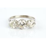 A DIAMOND THREE STONE RING, the graduated round brilliant-cut diamonds in claw setting, white